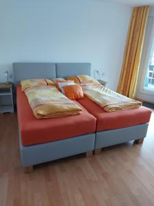 Bett mit Kissen darauf in einem Zimmer in der Unterkunft Rosenalm App 23 in Scheidegg