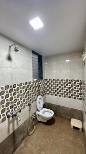 a bathroom with a toilet and a shower at Hrishivan Resort Nagaon in Nagaon