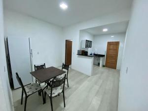 a dining room with a table and chairs and a kitchen at Alemanha aconchego in São Luís