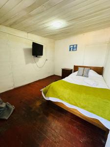 a bedroom with a bed and a tv on the wall at Hostal 3 Norte in San Antonio