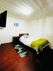 a bedroom with a bed with a green blanket on it at Hostal 3 Norte in San Antonio