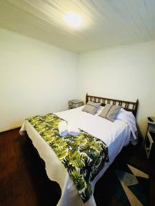 a bedroom with a large white bed with a green blanket at Hostal 3 Norte in San Antonio