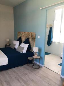 een slaapkamer met een blauw bed en een tafel met een lamp bij La possibilité d'une île in Boyardville