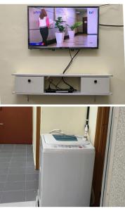 a tv sitting on top of a desk with a washing machine at Wafiy Homestay in Machang