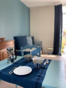 een tafel met twee kopjes en een blauwe tafeldoek bij La possibilité d'une île in Boyardville