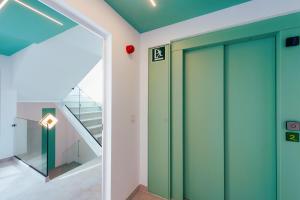 a hallway with a green door and a staircase at HC Calahonda Beach Nerja in Nerja