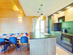 a kitchen with a table and blue chairs in a room at Appartement Villard-sur-Doron, 5 pièces, 10 personnes - FR-1-594-226 in Villard-sur-Doron