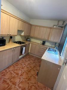 a kitchen with wooden cabinets and a tile floor at Cosy Nest Getaways in Hickleton