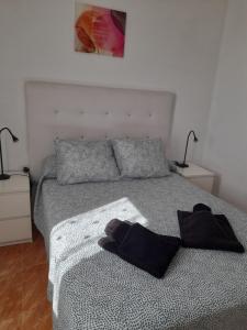 a bedroom with a bed with two black towels on it at apartamento MAKTUB in Puerto del Carmen