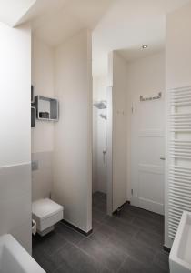 ハイリゲンハーフェンにあるOstsee - Reetdachhaus Nr 4 "Ostseeperle" im Strand Resortの白い壁のバスルーム(トイレ、洗面台付)