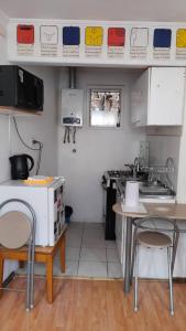 eine kleine Küche mit 2 Stühlen und einem Tisch in der Unterkunft Historia y comodidad in Valparaíso