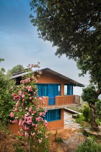 a house with blue doors and a tree at Kot Kailash Kumaon in Almora