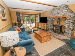 a living room with a blue couch and a stone fireplace at Hafan Dawel in Llanfyrnach