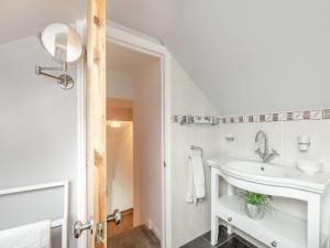 a white bathroom with a sink and a mirror at Beacon - Uk44719 in Ravenscar