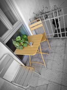 uma cadeira amarela e uma planta sobre uma mesa em Corte del Fuin - Dreaming Italy Travel em Seregno
