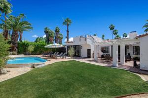 a villa with a swimming pool and palm trees at Famous Movie Colony Estate- Casa de Amigos Estate- Ultra Luxe, Pool, Spa, Firepit 4bd, 3.5bth in Palm Springs