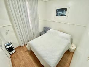 a small room with a white bed in it at Portal do Jaragua in Belo Horizonte