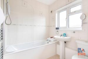 a white bathroom with a tub and a sink at OnSiteStays - Cosy 2-Bedroom Apartment with Private Entrance & Long Stay Prices in Gravesend