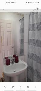 ein Badezimmer mit einem weißen Waschbecken und einem Spiegel in der Unterkunft Historia y comodidad in Valparaíso