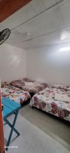 Habitación con 3 camas y una mesa azul. en Hostal Makesa Tatacoa, en Villavieja
