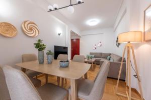 a dining room and living room with a table and chairs at AinCAC Apartment Athens Center in Athens
