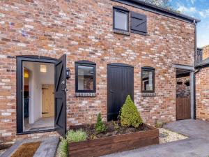 a brick house with black doors and windows at Eleni Loulou - Uk43585 in Ellesmere