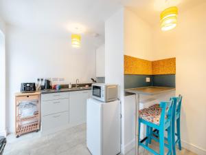 a kitchen with white cabinets and a table and chairs at Eleni Loulou - Uk43585 in Ellesmere