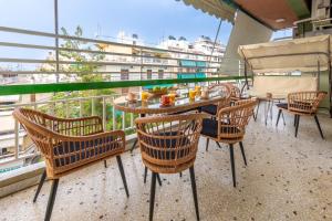a balcony with chairs and a table with food on it at AinCAC Apartment Athens Center in Athens