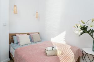 a bedroom with a bed with pink and blue pillows at Wiktoryn 21 Citysphere Premium Suite 2 in Warsaw