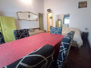 Habitación con cama y mesa roja con sillas. en Refugio Porteño en Buenos Aires