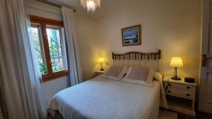 een slaapkamer met een wit bed en een raam bij Aurea in La Losa