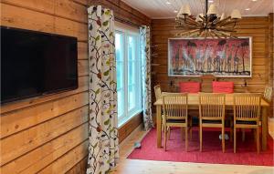a dining room with a table and a flat screen tv at Lovely Home In Mora With Sauna in Mora