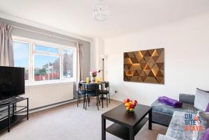uma sala de estar com um sofá e uma mesa em OnSiteStays - Cosy 2-Bedroom Apartment with Private Entrance & Long Stay Prices em Gravesend
