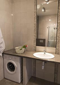 a bathroom with a washing machine and a sink at Apartament MAJA Giżycko Żeglarska in Giżycko