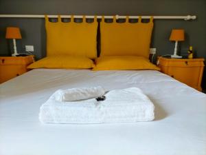 a white towel sitting on top of a bed at Corte del Fuin - Dreaming Italy Travel in Seregno