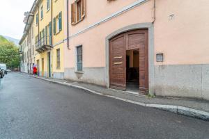 een gebouw met een houten deur aan de straatkant bij Sericum Apartment by Wonderful Italy in Como