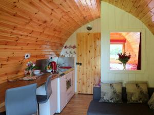 a kitchen with a couch and a counter in a room at Barley Hill Pod in Broadway