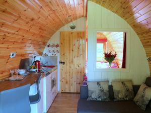a kitchen with a couch in a tiny house at Barley Hill Pod in Broadway