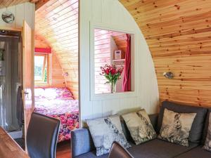 a living room with a couch and a bedroom at Barley Hill Pod in Broadway