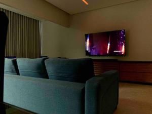 um quarto com cadeiras azuis e uma televisão de ecrã plano em Apt novo (com ar condicionado) Santa Teresa - ES em Santa Teresa