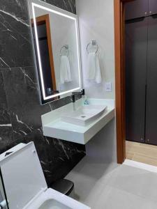uma casa de banho com um lavatório, um WC e um espelho. em Apt novo (com ar condicionado) Santa Teresa - ES em Santa Teresa