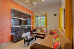a living room with a couch and a tv at Coorg Vacation Stay(KKR) in Madikeri