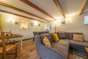 a living room with a couch and a table at Mill House Cottage in Brancaster