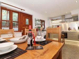 a kitchen with a wooden table with wine glasses on it at Cherry Tree Cottage in Windermere