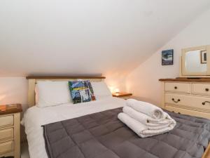 a bedroom with a bed with towels on it at Cherry Tree Cottage in Windermere