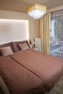 Un dormitorio con una cama grande y una lámpara de araña. en Imádnivaló társasházi lakás, en Mosonmagyaróvár