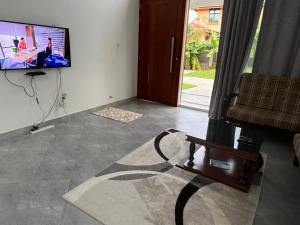 un soggiorno con TV a schermo piatto e divano di Datela Home - 3Bed Villa near Ununio Beach Kunduchi a Dar es Salaam