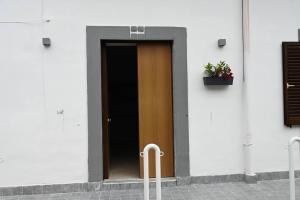 una porta marrone su un edificio bianco con una pianta in vaso di House by the station -Close to Oplonti Ruins a Torre Annunziata