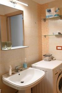 ein Badezimmer mit einem Waschbecken und einer Waschmaschine in der Unterkunft White Oplonti House in Torre Annunziata