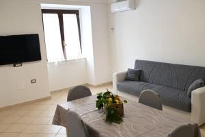 ein Wohnzimmer mit einem Tisch und einem Sofa in der Unterkunft White Oplonti House in Torre Annunziata